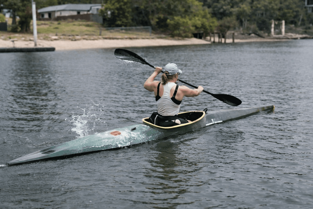Susanna Wills kayaking through calm waters on a sunny day, training for Brisbane 2032